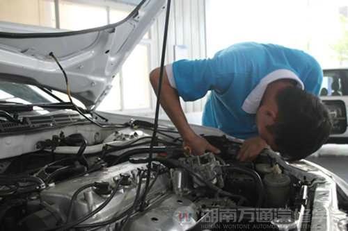 萬(wàn)通汽修學(xué)生對(duì)實(shí)訓(xùn)設(shè)備進(jìn)行檢修中