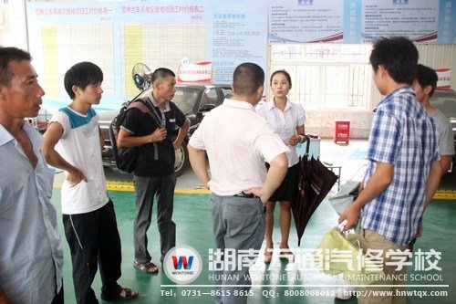 在高級(jí)轎車實(shí)訓(xùn)中心，咨詢老師給學(xué)生及其家人講述要學(xué)習(xí)的課程
